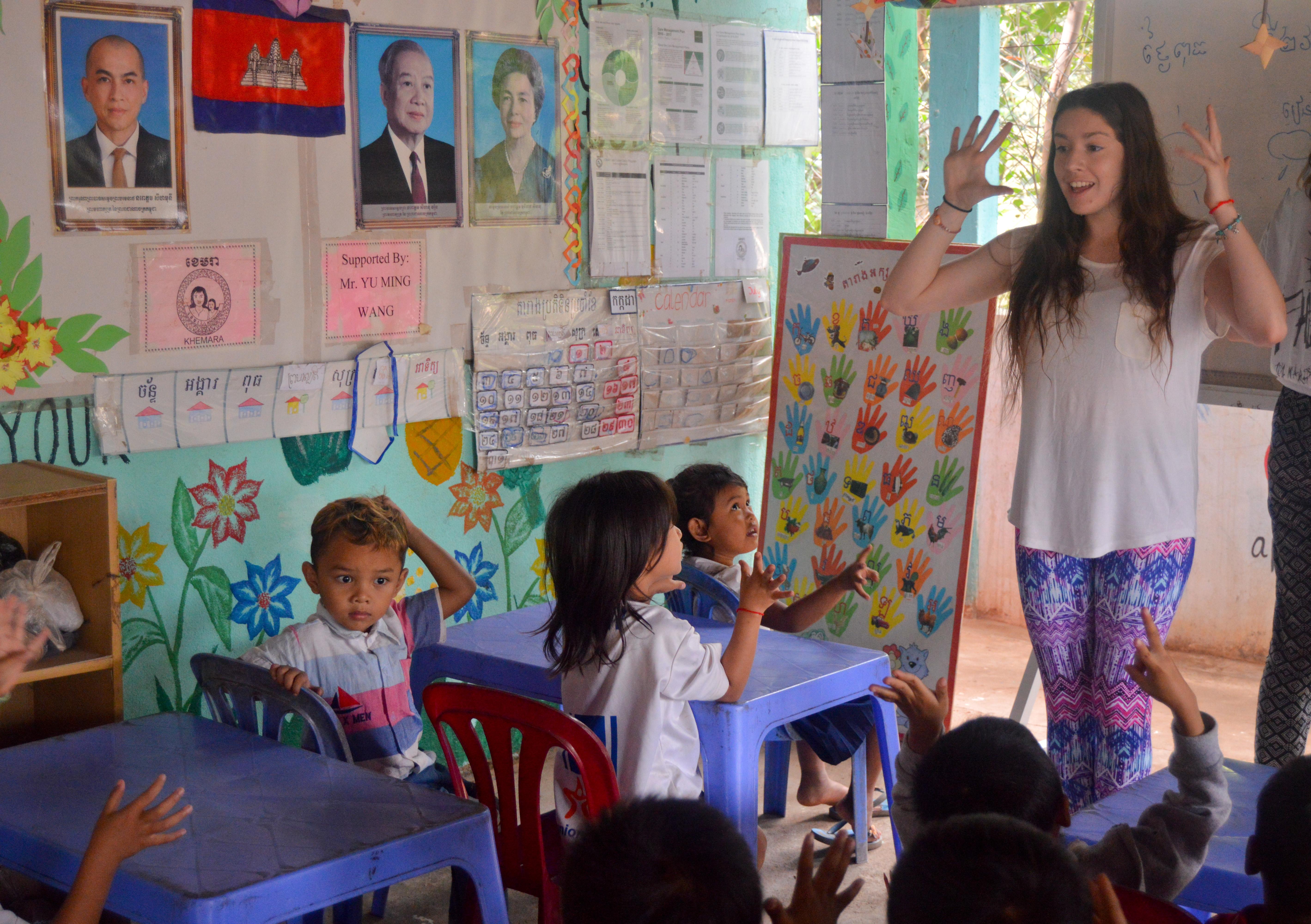 Children are taught by female volunteers working with children in Cambodia inside a community care centre to further their childhood development. Projects Abroad Childcare volunteer helps children improve their English skills a a local community centre in Cambodia.